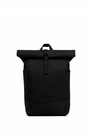 Zaino nero con chiusura roll-top, fibbia frontale, tasche laterali e maniglia superiore su sfondo bianco.