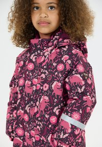 Pigejakke med hætte i mørk lilla, prydet med pink dyre- og blomstermotiver. Inkluderer reflekterende detaljer på ærmerne.