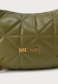 Olivno zeleni kvačkani usnjeni nahrbtnik z zlatim logotipom "justcavalli". Ima gladko teksturo in izrazit diagonalni šivni vzorec.