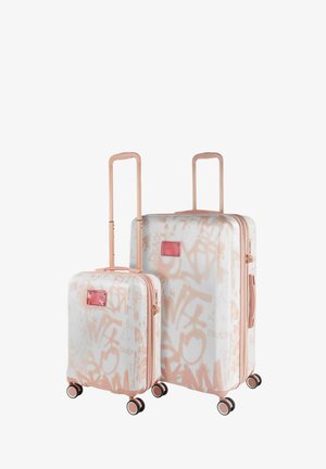 Dos maletas rígidas en blanco con patrones de grafiti rosa, con detalles en rosa dorado, ruedas dobles y asas retráctiles.