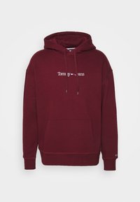 Felpa con cappuccio color bordeaux, con tasca frontale, polsini a coste e logo bianco "Tommy Jeans". Realizzata in morbido tessuto misto cotone.