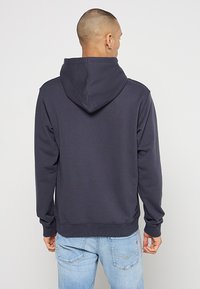 Dunkelblaues Hoodie mit gerippter Textur, verstellbarer Kapuze und langen Ärmeln. Hat einen geraden Schnitt und einen gerippten Saum.
