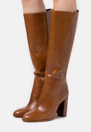 Stivali marroni in pelle al ginocchio con punta squadrata, cerniera laterale e tacco impilato texturizzato. Texture liscia e design elegante.