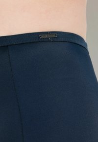 Navyblauwe, gladde stoffen legging met een platte tailleband. Voorzien van een genaaid label met het logo "Lilla Poyn" op de taille.