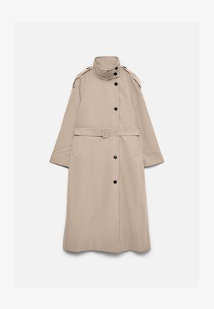 Lang beige trenchcoat med høy krage, svarte knapper, skulderklaffer, belte i midjen og sidelommer, lagt flatt på hvit bakgrunn.
