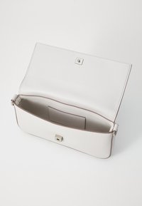 Bolso de mano blanco de cuero con un cierre a presión cuadrado plateado. El interior cuenta con un bolsillo con ranura para tarjetas y un forro suave.