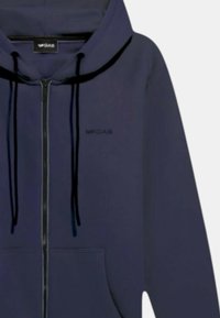 Felpa con zip color navy, con lacci, tasche anteriori e un piccolo logo. Realizzata in materiale morbido con una texture liscia.