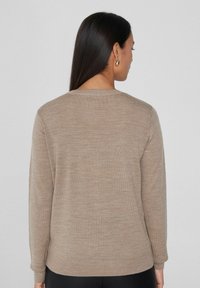 Beige Pullover mit langen Ärmeln, rundem Halsausschnitt, gerippten Bündchen und Saum. Glatte Textur mit einem feinen, dezenten Strickmuster.