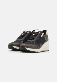 Mustad mustad sneakers kuldsete aktsentidega, seemisnahast ja kangast materjalidest, tekstureeritud pruuni mustriga varbakaitse, platvormpohja ja kontrastsed paelad.