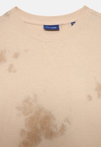 Beżowy sweter z teksturowanym, nieregularnym wzorem. Posiada okrągły dekolt i widoczne detale szycia. Metka brzmi "ONLY & SONS."