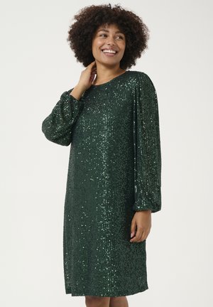 Robe verte à sequins avec de longues manches bouffantes, longueur genou et une silhouette droite. Surface brillante et texturée avec un effet scintillant.