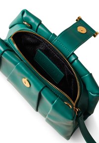 Grüne Lederhandtasche mit gestepptem Design, goldenen Beschlägen, Reißverschluss und einer strukturierten schwarzen Innenauskleidung, die sichtbar ist.