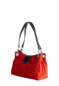 Punainen mokkanahkainen käsilaukku, jossa on musta nahkakoriste ja sileät kahvat. Varustettu metallisella tarvikkeella ja rakenteellisella muodolla, jossa on tilava sisustus.