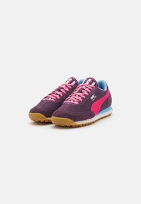 Adidași din stofă purpurie cu accente roz, panouri din plasă și velur texturat. Prezintă un design cu șireturi, talpă din cauciuc și detalii de un albastru deschis.