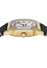 Montre dorée avec un boîtier octogonal, cadran clair montrant des chiffres romains, bracelet noir texturé et une couronne proéminente.