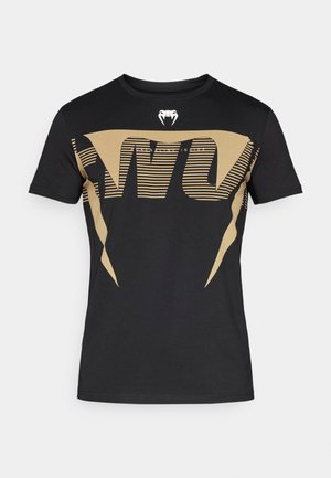 Melnas kokvilnas T-krekls ar lielu, drosmīgu zelta grafisko dizainu ar svītrām un kobras logotipu krūtīs. Klasisks apaļas apkakles stils.