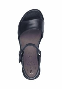 Sandale en cuir noir avec une large sangle sur le bout et une boucle ajustable à la cheville. Doublure intérieure douce et semelle ergonomique.