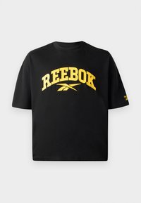 Melns kokvilnas t-krekls ar īsām piedurknēm. Priekšā ir drosmīgs dzeltenais "REEBOK" teksts un logo. Krekls ir taisnstūra piegriezuma un ar apaļu kakla izgriezumu.