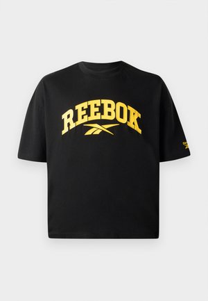 T-shirt nera in cotone con maniche corte. Presenta il logo e il testo "REEBOK" in giallo bold sulla parte anteriore. Design boxy e scollo rotondo.
