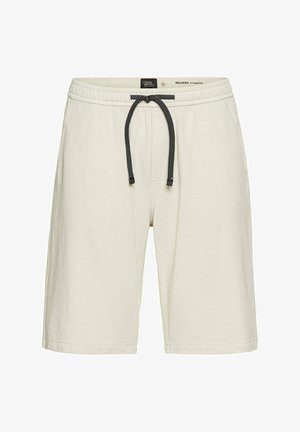 Kremowe szorty o luźnym kroju wykonane z miękkiego materiału, z elastycznym pasem ze sznurkiem w czarno-białym wzorze.