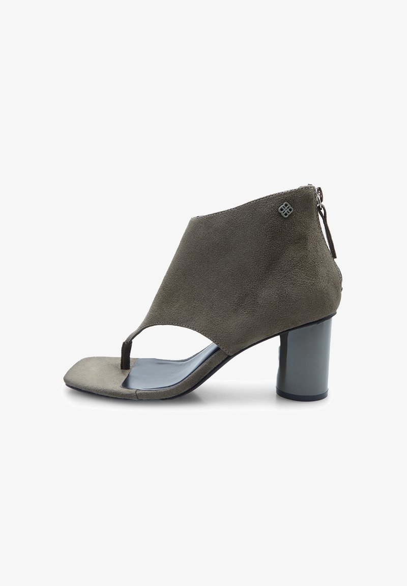 Halli halliga sandaal, millel on avatud disain ja plokk-kand. Peep toe ja väike logo aksent vetthülgiva luku lähedal taga.