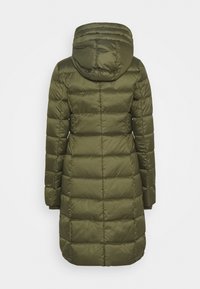 Olivenfarbene Steppjacke mit Kapuze, gestepptem Design und elastischen Bündchen. Das Material wirkt glänzend und isoliert und reicht bis zur Mitte des Oberschenkels.