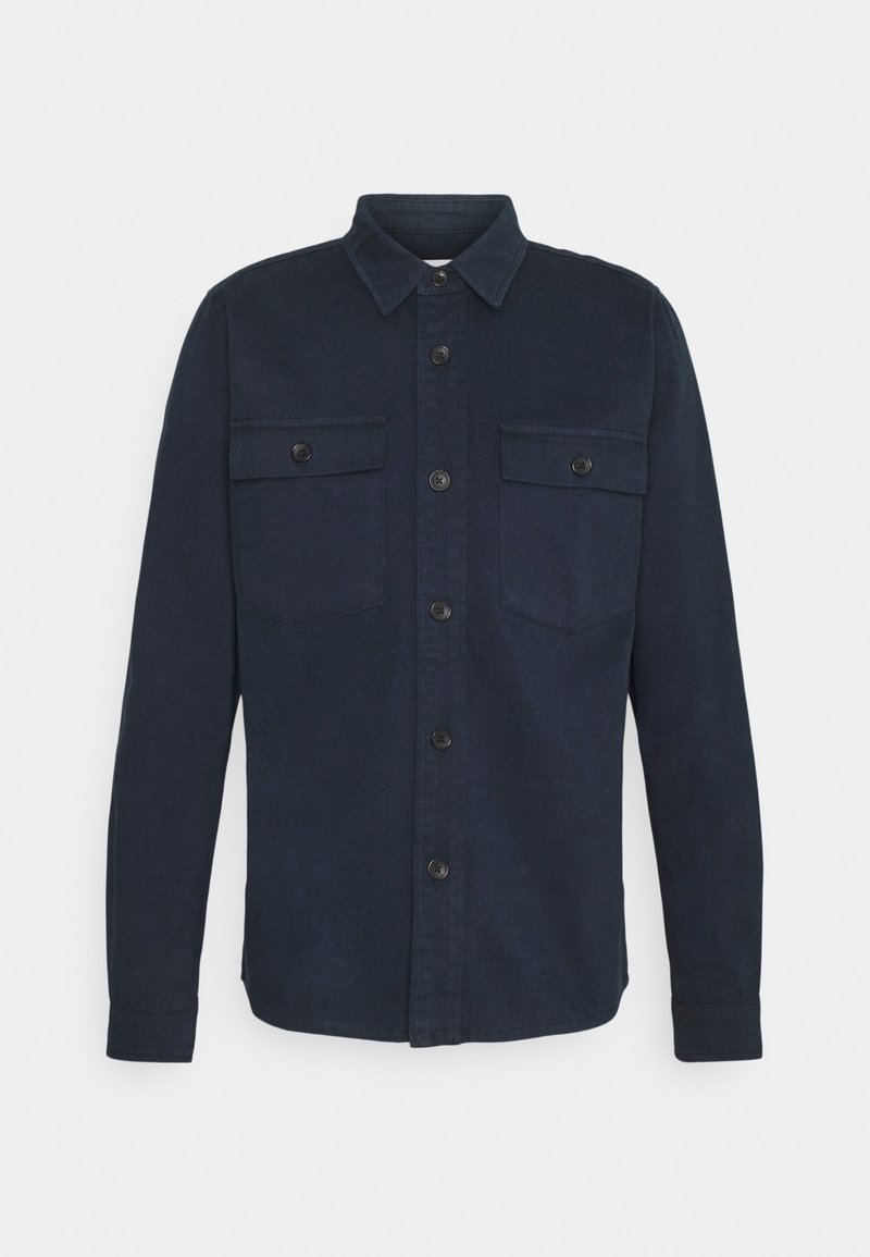Chemise bleu marine foncé à manches longues, col, fermeture boutonnée sur le devant et deux poches poitrine à boutons.