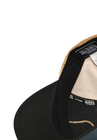 Gorra negra con visera redondeada, con un forro interior color beige y una etiqueta de marca cosida en el interior. La parte frontal tiene una tela texturizada con acentos.