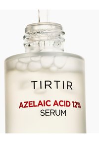 Primo piano di una boccetta di siero in vetro frosting etichettata "TIRTIR Siero di Acido Azelaico 12%" con gocce di liquido all'interno e un contagocce che distribuisce il siero.