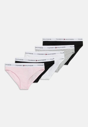 Pet hlačk za ženske v roza, črni, beli in sivi barvi, vsake s belim pasom, na katerem je napis "Tommy Hilfiger" in logotip.