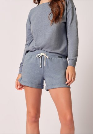 Grå langermet topp med rullemansjetter kombinert med matchende grå shorts med snøring i livet og brettet kant. Myk stofftekstur.