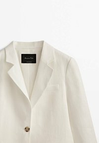Blazer ajusté blanc à un seul bouton avec des revers crantés et une poche-poitrine passepoilée, étiqueté Massimo Dutti, fabriqué au Portugal.