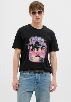Sort bomulds t-shirt med et farverigt grafisk print af fire figurer med teksten "VI ER NERDS & FREAKS!" i livlige farver.