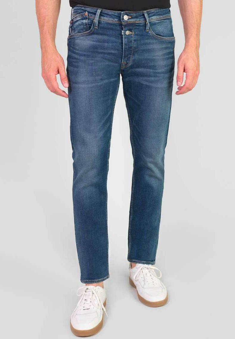 Blauwe denim jeans met een slim fit, voorzien van een vervaagde afwerking, vijf-pocket ontwerp en zilveren hardware. Gecombineerd met witte sneakers.