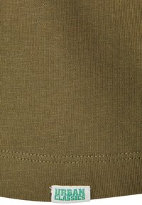 Olivgrüner Baumwollstoff mit strukturiertem Ribben. Enthält ein Saumetikett mit der Aufschrift "Urban Classics" in Weiß mit grüner Schrift.
