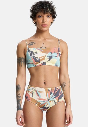 Dwuczęściowy strój kąpielowy z kwiatowym wzorem w pastelowych kolorach. Góra ma kwadratowy dekolt i cienkie ramiączka; dół jest z wysokim stanem.