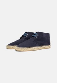 Mornarske suknjaste espadrile s jute užetom, s plavim vezicama i detaljima teksturirane bočne panele.