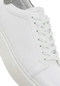 Baskets en cuir blanc avec une finition lisse, bout rond et semelle en caoutchouc blanc texturé. Elles sont dotées de lacets blancs et d'un accent gris à l'arrière.