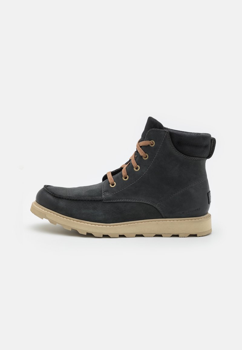 Botas de cuero negro hasta el tobillo con cordones marrones, puntera redonda y suela de goma contrastante. Presentan detalles de costura y un diseño de tobillo que ofrece soporte.