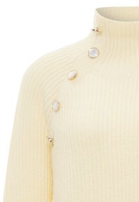 Pulover galben cu guler înalt din tricot cu caneluri, decorat cu elemente metalice aurii și accente circulare albe pe umeri, având un design ajustat.