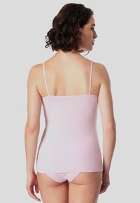 Light pink tank top with thin straps, made of soft material, smooth texture, minimal design, and a fitted shape. Paired with matching briefs.