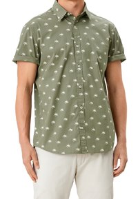 Camisa de manga corta en color verde olivo, hecha de tela ligera, con un patrón de palmeras blancas y un cierre frontal con botones y mangas enrolladas.