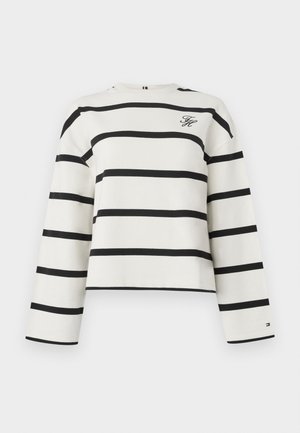 Striped long-sleeve top in white cotton with black horizontal stripes. Features a crew neck and logo detail on the chest. Cropped fit.