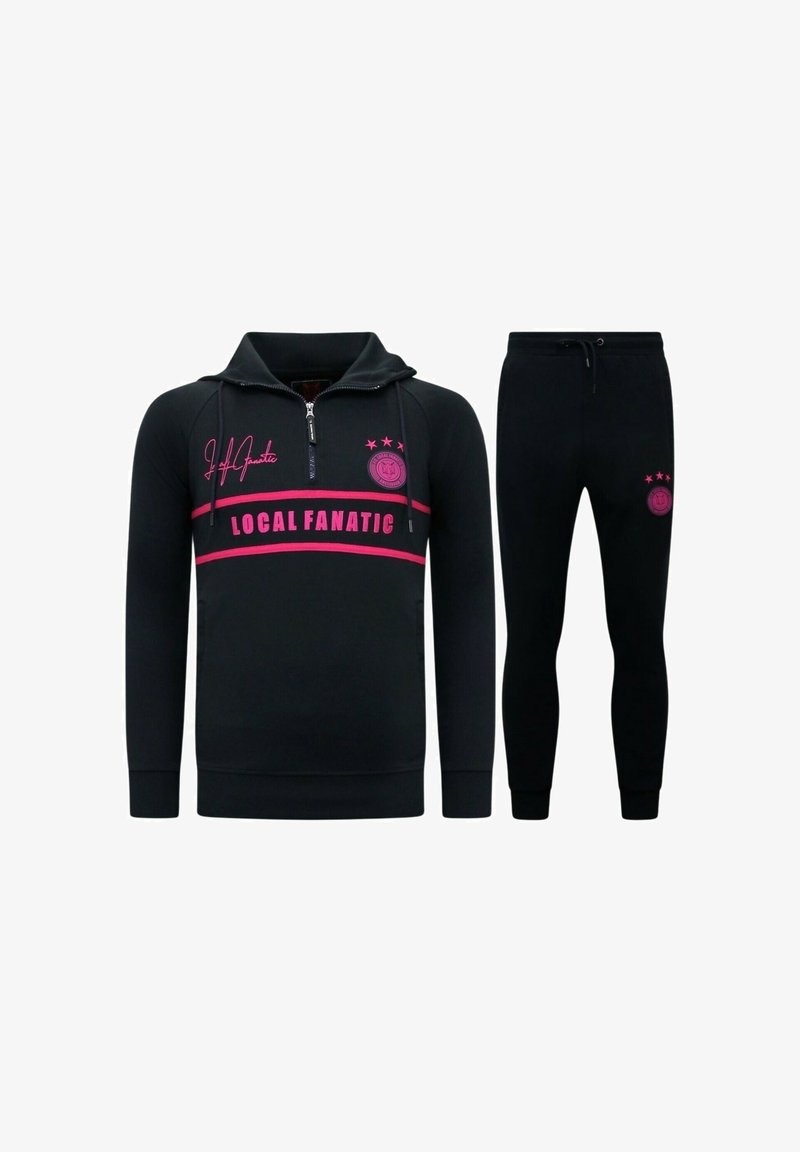Zwarte trainingspak met een zip-up hoodie met roze accenten en de tekst "LOCAL FANATIC", gecombineerd met bijpassende slim-fit broek.