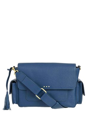 Sac bandoulière en cuir bleu avec fermeture à rabat, sangle réglable, poches latérales, ferrures dorées et un détail de pompon sur un côté.