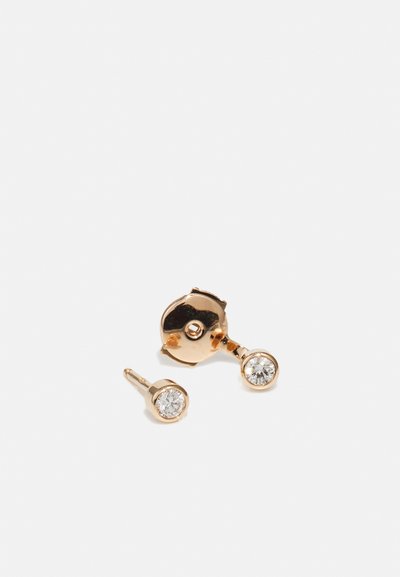 Guldtonede studs med klare runde krystaller, hver sat i en cirkulær bezelsæt. Glat overflade med en poleret finish.