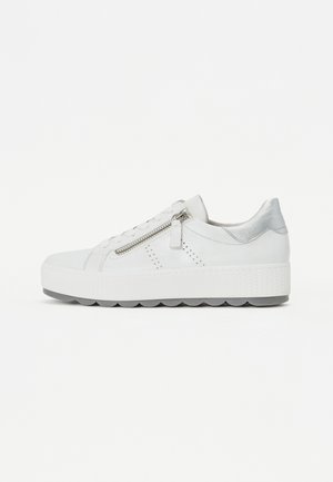 Sneaker in pelle bianca con suola in gomma piatta. Presenta un tallone in metallo argentato, una cerniera laterale e un design perforato per la ventilazione.