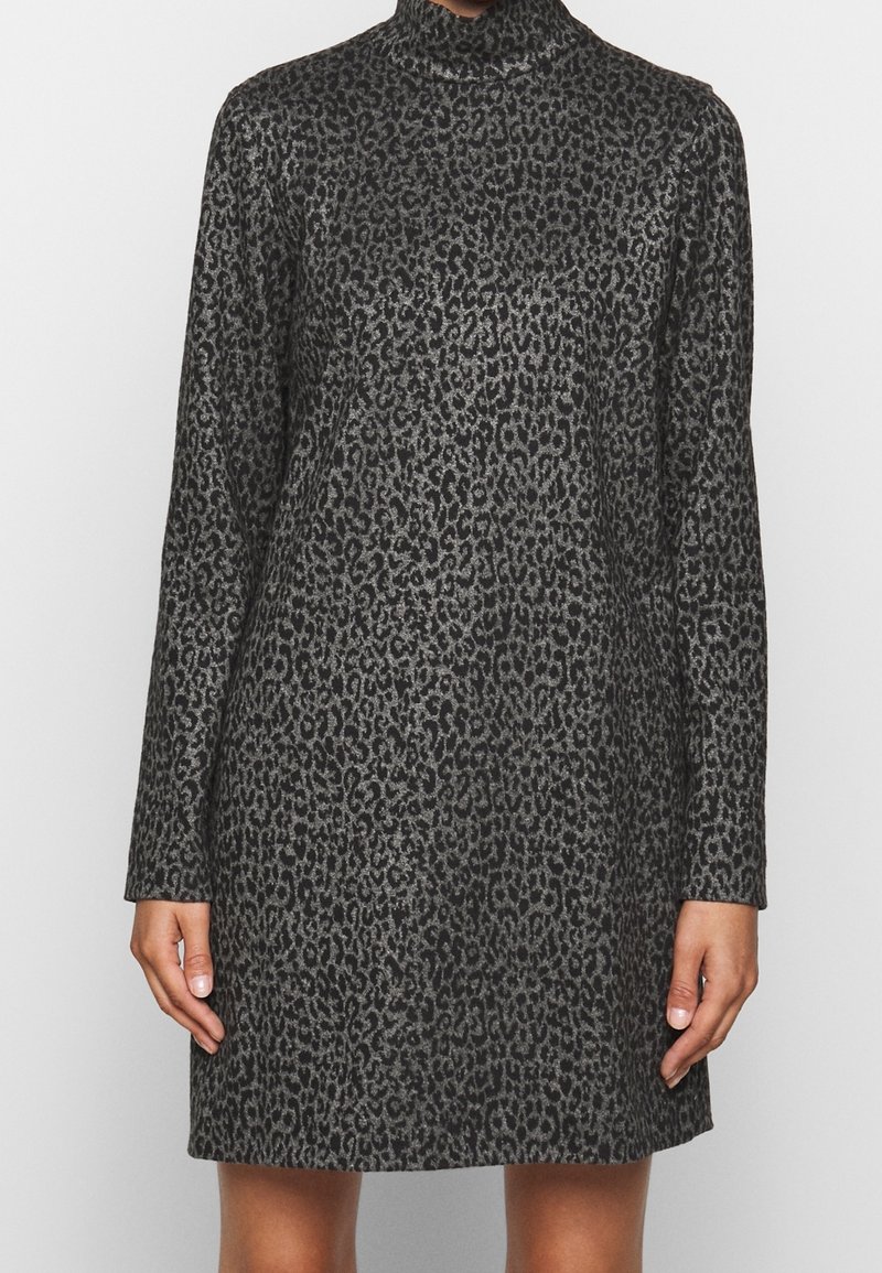 Femme portant une robe gris foncé à manches longues, col montant et longueur au genou avec un motif léopard noir.