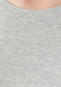 Grijs geribbeld stof met een zachte textuur, met een ronde halslijn en subtiele kleurvariaties overal.