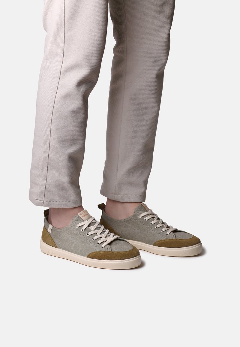 Baskets basses pour hommes en toile grise et vert olive avec des accents en daim beige et un système de laçage, présentant une semelle texturée.